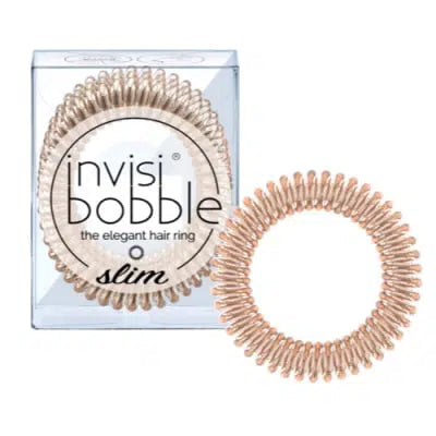 A bronze-colored spiral-shaped hair tie packaged in a clear plastic box with the brand name 'Invisibobble' displayed on the side.