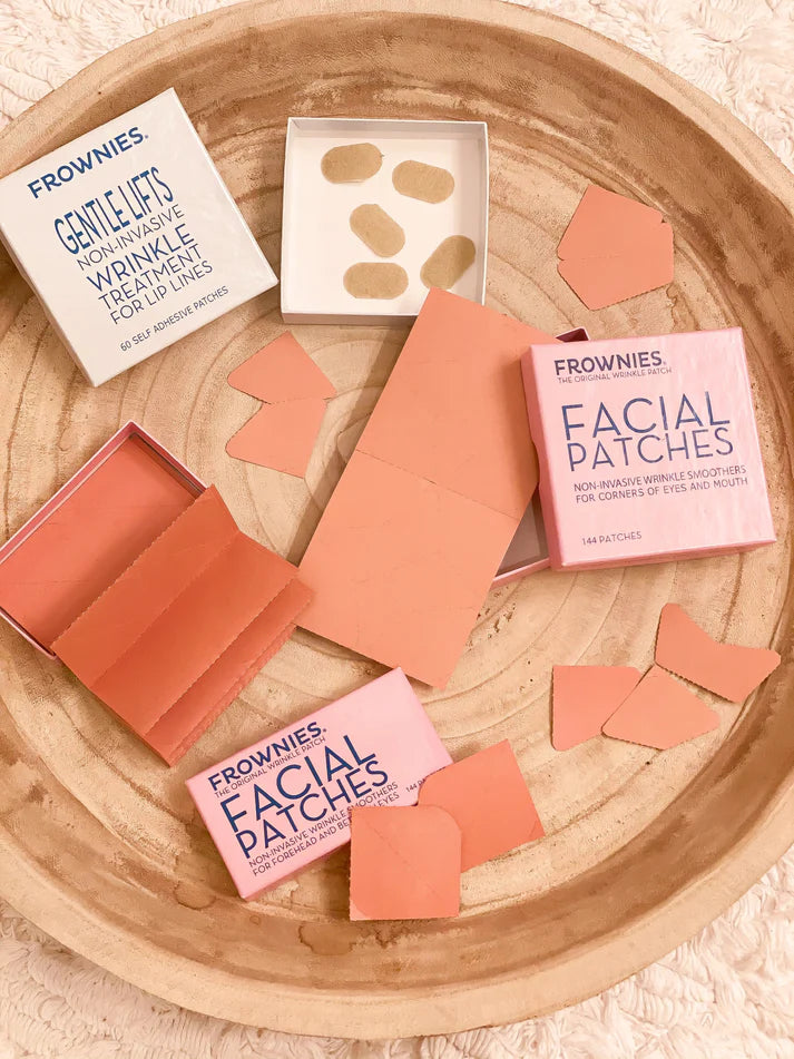 Frownies facial patches trial pack, including various shaped patches in beige and pink, with packaging and individual patches displayed on a wooden surface.