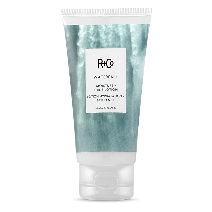 A travel size tube of R+Co WATERFALL Moisture + Shine Lotion.