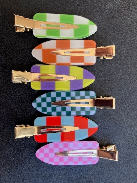Colorful checkered hair clips on a dark background